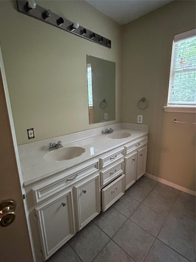 full bathroom with double vanity, a sink, and tile patterned floors