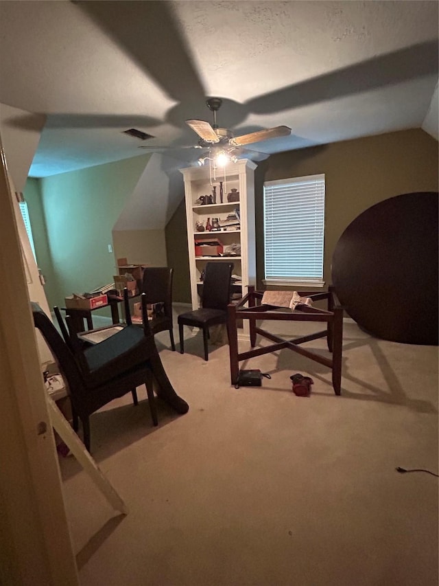 bedroom with visible vents, a ceiling fan, vaulted ceiling, and light carpet