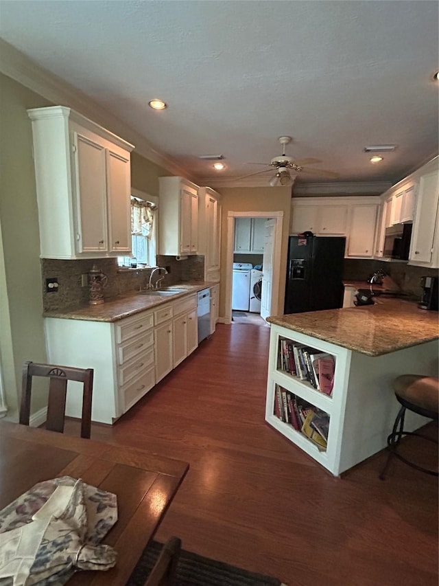 kitchen with washer and dryer, white cabinets, black refrigerator with ice dispenser, and dishwasher