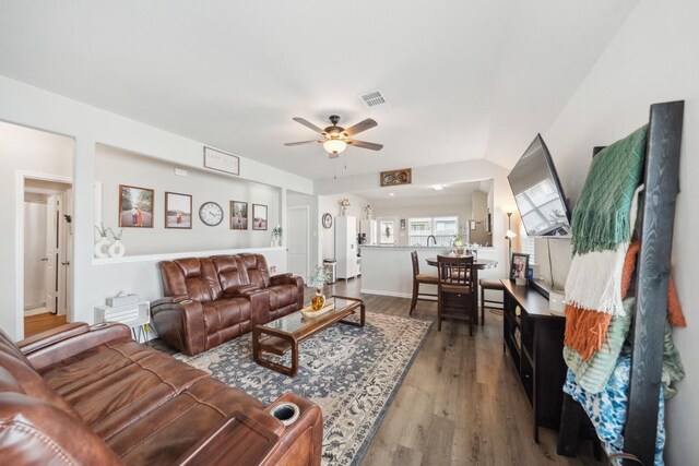 living room with visible vents, a ceiling fan, and wood finished floors