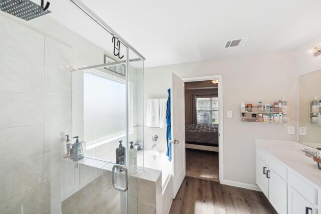 bathroom featuring ensuite bath, vanity, a shower stall, wood finished floors, and visible vents