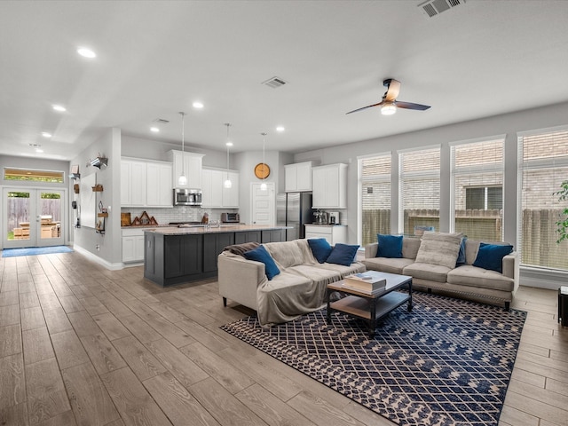 living room with recessed lighting, ceiling fan, light wood finished floors, and visible vents