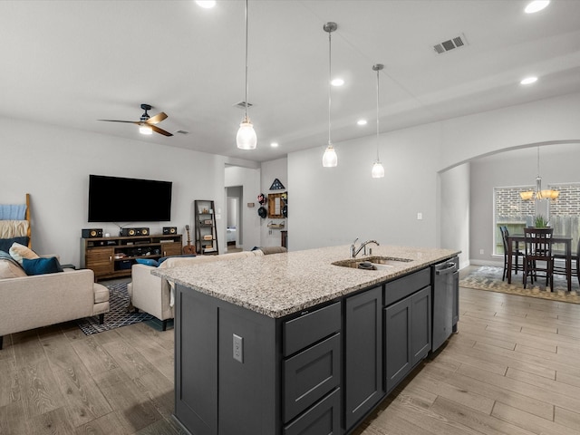 kitchen with stainless steel dishwasher, a sink, visible vents, and light wood-type flooring