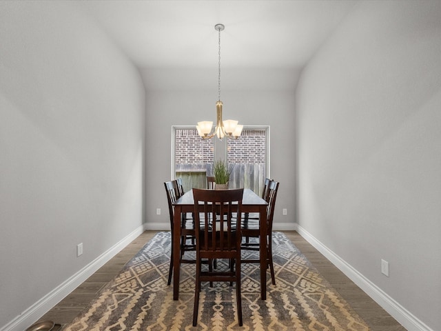dining area with baseboards, dark wood-style floors, and a chandelier