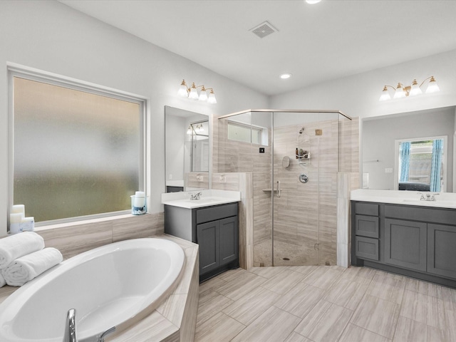 bathroom with a sink, two vanities, a shower stall, visible vents, and a bath
