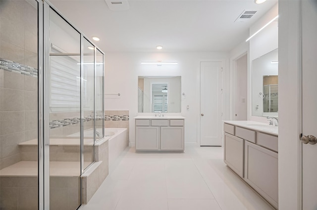 bathroom featuring a sink, tile patterned flooring, a shower stall, visible vents, and a garden tub