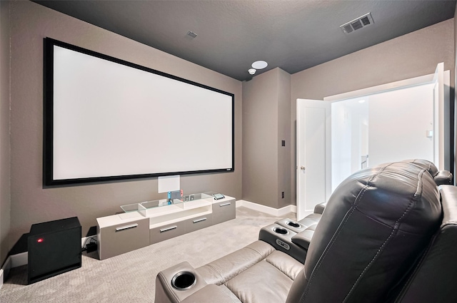 carpeted cinema with visible vents and baseboards
