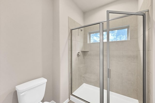 full bathroom featuring a stall shower and toilet