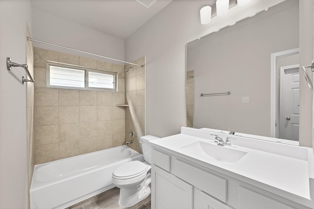 bathroom featuring vanity, wood finished floors, toilet, and shower / washtub combination