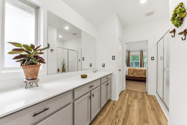 bathroom featuring a shower stall, wood finished floors, vanity, ensuite bathroom, and recessed lighting