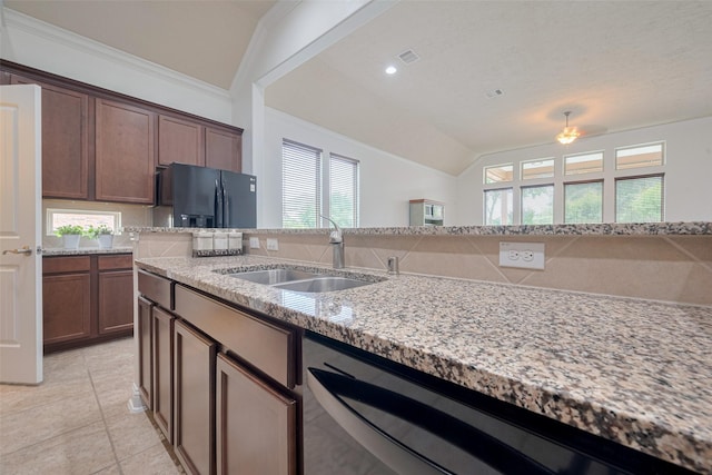 kitchen with vaulted ceiling, a sink, dishwashing machine, black fridge, and a wealth of natural light
