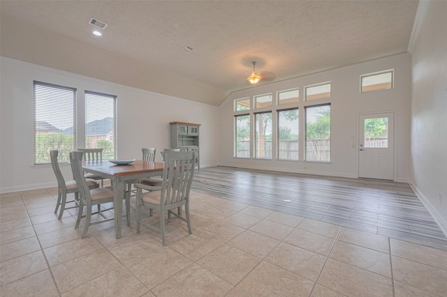 dining area featuring baseboards, a textured ceiling, and light tile patterned floors