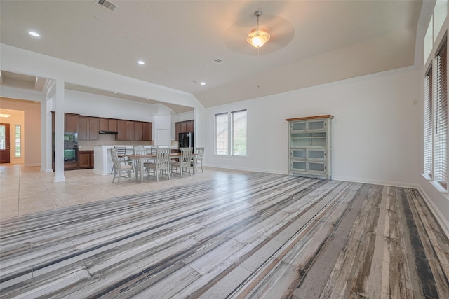 unfurnished living room featuring baseboards, plenty of natural light, and light wood-style floors