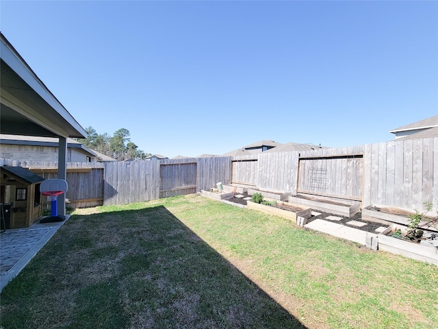 view of yard with a fenced backyard and a garden