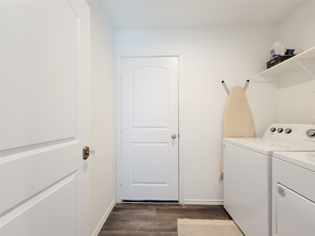 laundry area featuring baseboards, laundry area, dark wood-style floors, and washer and clothes dryer
