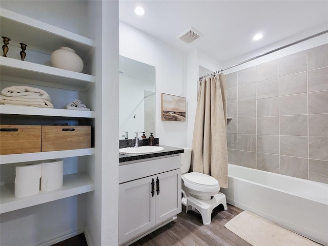 bathroom featuring visible vents, vanity, wood finished floors, toilet, and shower / bathtub combination with curtain