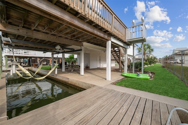 22118 Matagorda Dr, Galveston, TX 77554 - view of dock with fence, a deck, a lawn, and stairway