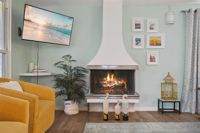 22118 Matagorda Dr, Galveston, TX 77554 - living area featuring a warm lit fireplace, baseboards, and wood finished floors
