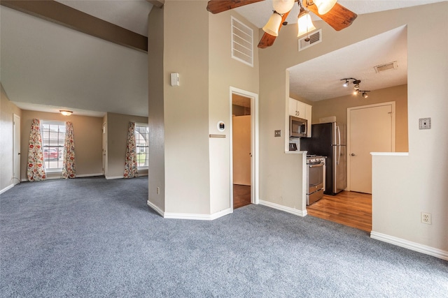 unfurnished living room with visible vents, carpet flooring, and ceiling fan