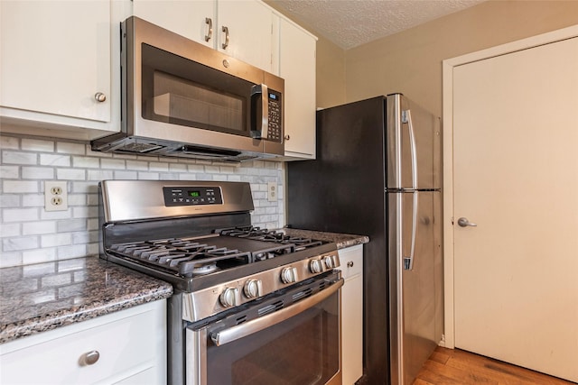 kitchen featuring backsplash, stainless steel appliances, light wood-type flooring, and white cabinetry