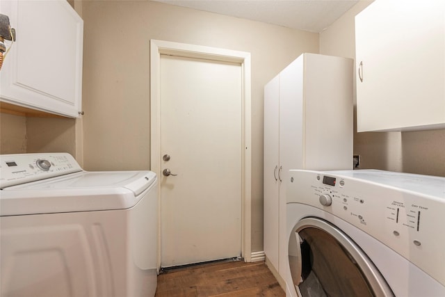 clothes washing area with washer and dryer, wood finished floors, and cabinet space