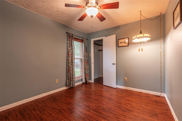 empty room with baseboards, a textured ceiling, ceiling fan, and wood finished floors