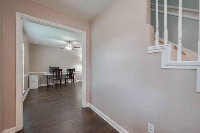 corridor featuring baseboards and dark wood-style flooring