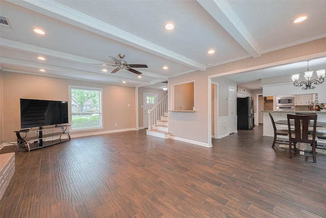 living area featuring ornamental molding, beamed ceiling, stairway, dark wood finished floors, and ceiling fan with notable chandelier