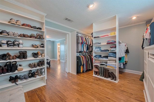 walk in closet featuring light wood-type flooring and visible vents