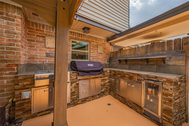 view of patio / terrace featuring fence, a sink, wine cooler, and area for grilling