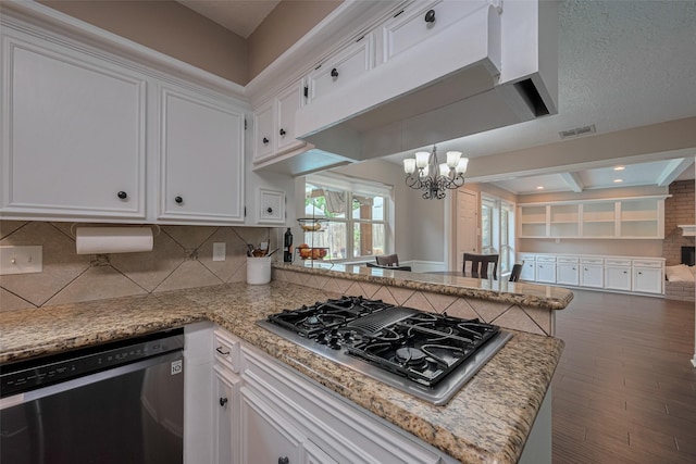 kitchen featuring white cabinets, stovetop with downdraft, dishwasher, a chandelier, and visible vents