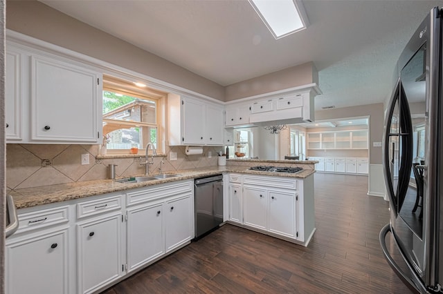 kitchen featuring a sink, stainless steel appliances, a peninsula, and dark wood-type flooring