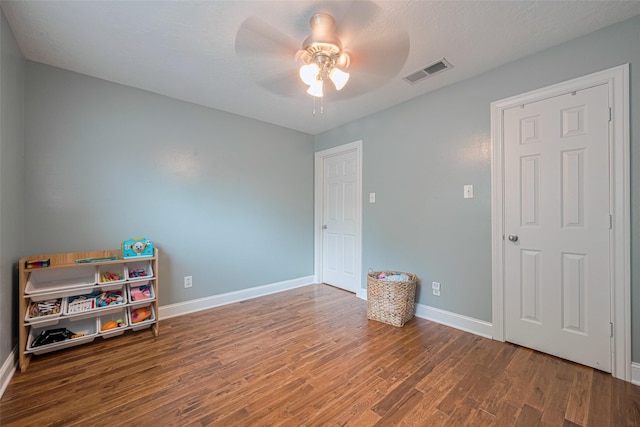 rec room featuring baseboards, ceiling fan, visible vents, and wood finished floors