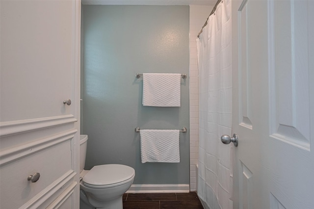 full bath featuring baseboards, toilet, curtained shower, and wood finished floors