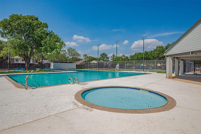 community pool with fence, a patio, and a shed