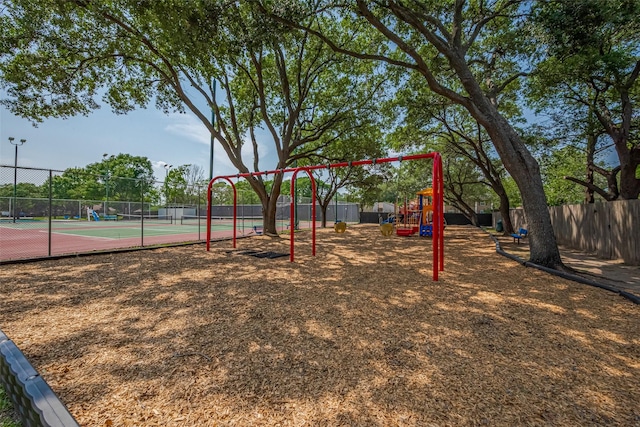 community playground with fence and a tennis court