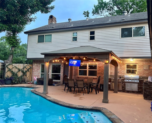 back of house featuring area for grilling, brick siding, a fenced in pool, fence, and a patio
