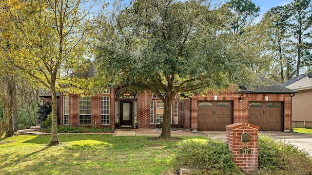 view of front of house with a garage, driveway, brick siding, and a front yard