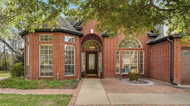 view of front of property featuring roof with shingles and brick siding