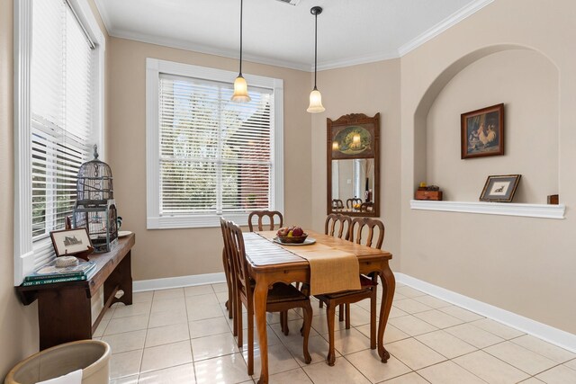 dining room featuring light tile patterned flooring, baseboards, ornamental molding, and a healthy amount of sunlight
