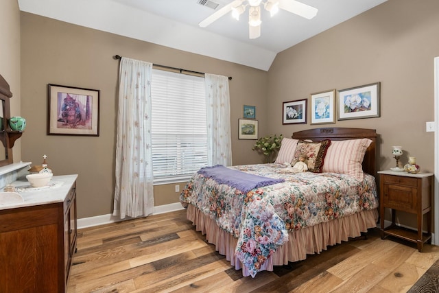 bedroom with baseboards, a ceiling fan, vaulted ceiling, and light wood-style flooring
