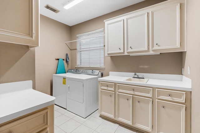 laundry area featuring visible vents, washing machine and dryer, cabinet space, a sink, and light tile patterned flooring