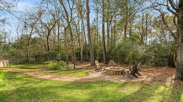 view of yard featuring fence, a fire pit, and a patio area