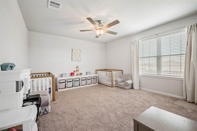 bedroom with baseboards, visible vents, a crib, and carpet