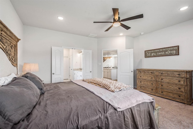carpeted bedroom featuring recessed lighting, ceiling fan, a sink, and ensuite bathroom