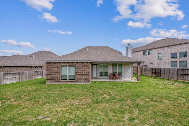 back of property with a fenced backyard, a yard, and a patio area