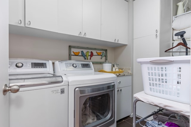 clothes washing area with washing machine and dryer and cabinet space