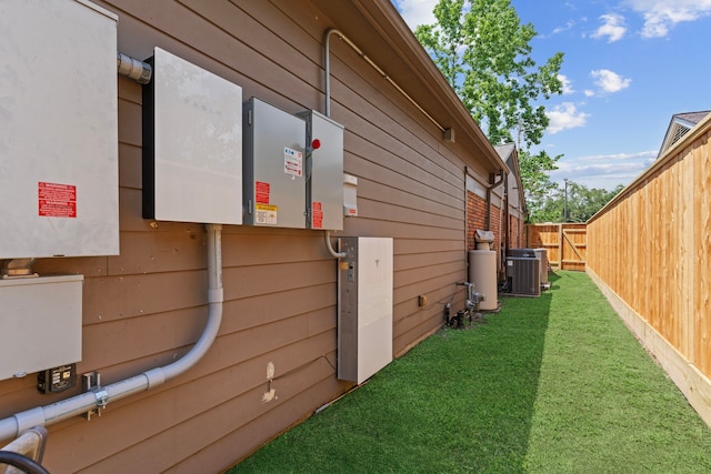 view of home's exterior featuring central air condition unit, a yard, and fence