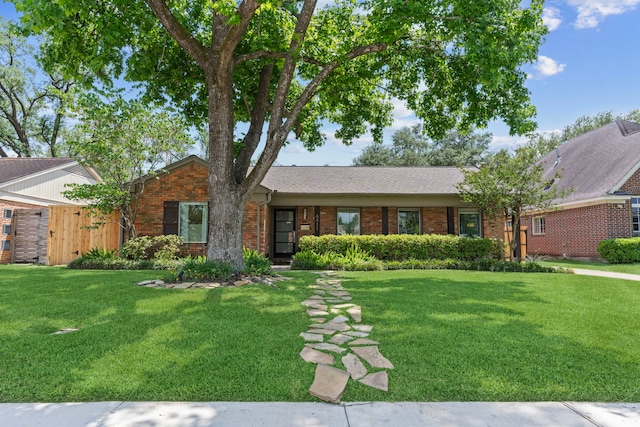 ranch-style home featuring brick siding and a front yard