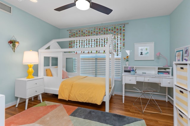 bedroom with visible vents, a ceiling fan, baseboards, and wood finished floors